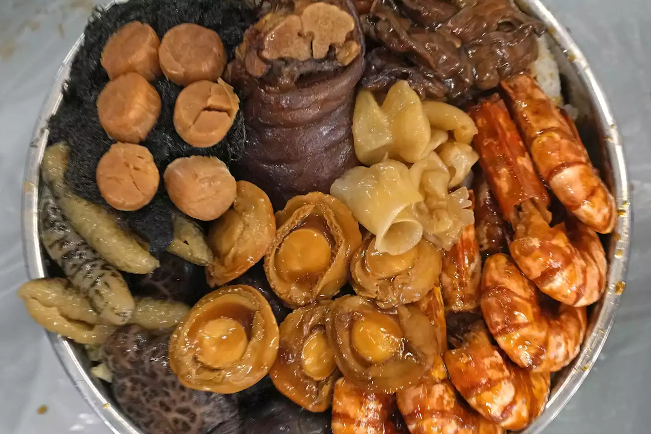 AP PHOTOS: Savoring lucky Lunar New Year's eve dish at home