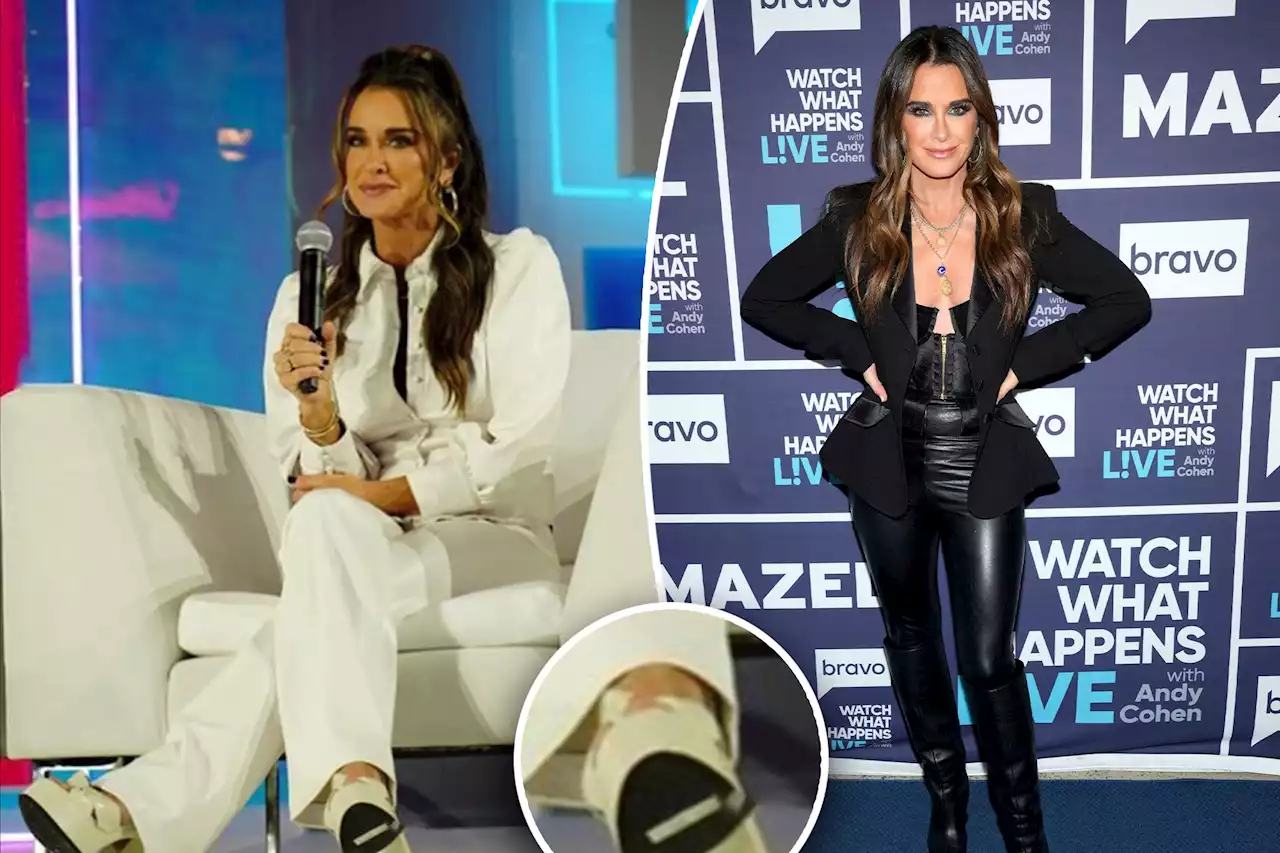 Kyle Richards reacts to being caught with a price tag on her shoe at BravoCon