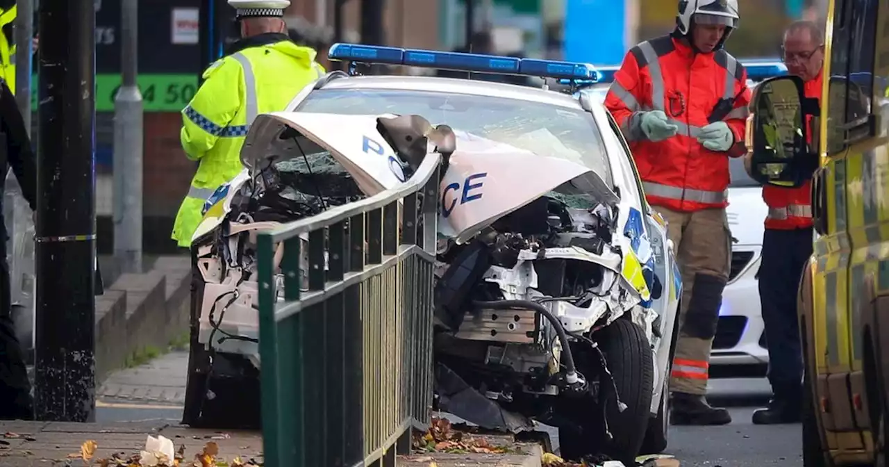 Road cordoned off after police car slams into barrier in serious crash