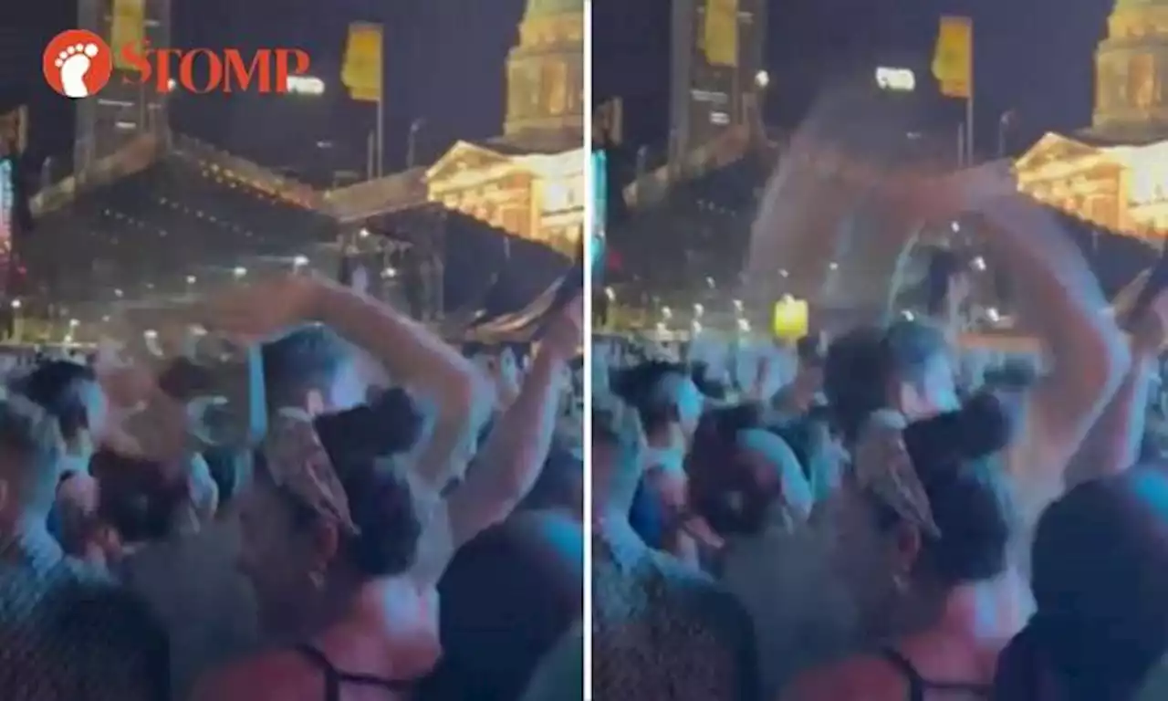 Audience member throws cup tray into crowd during Westlife performance at F1 concert