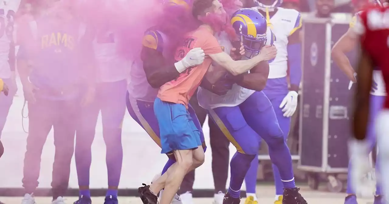 Rams linebacker Bobby Wagner tackles a fan who ran onto the field during Monday Night Football