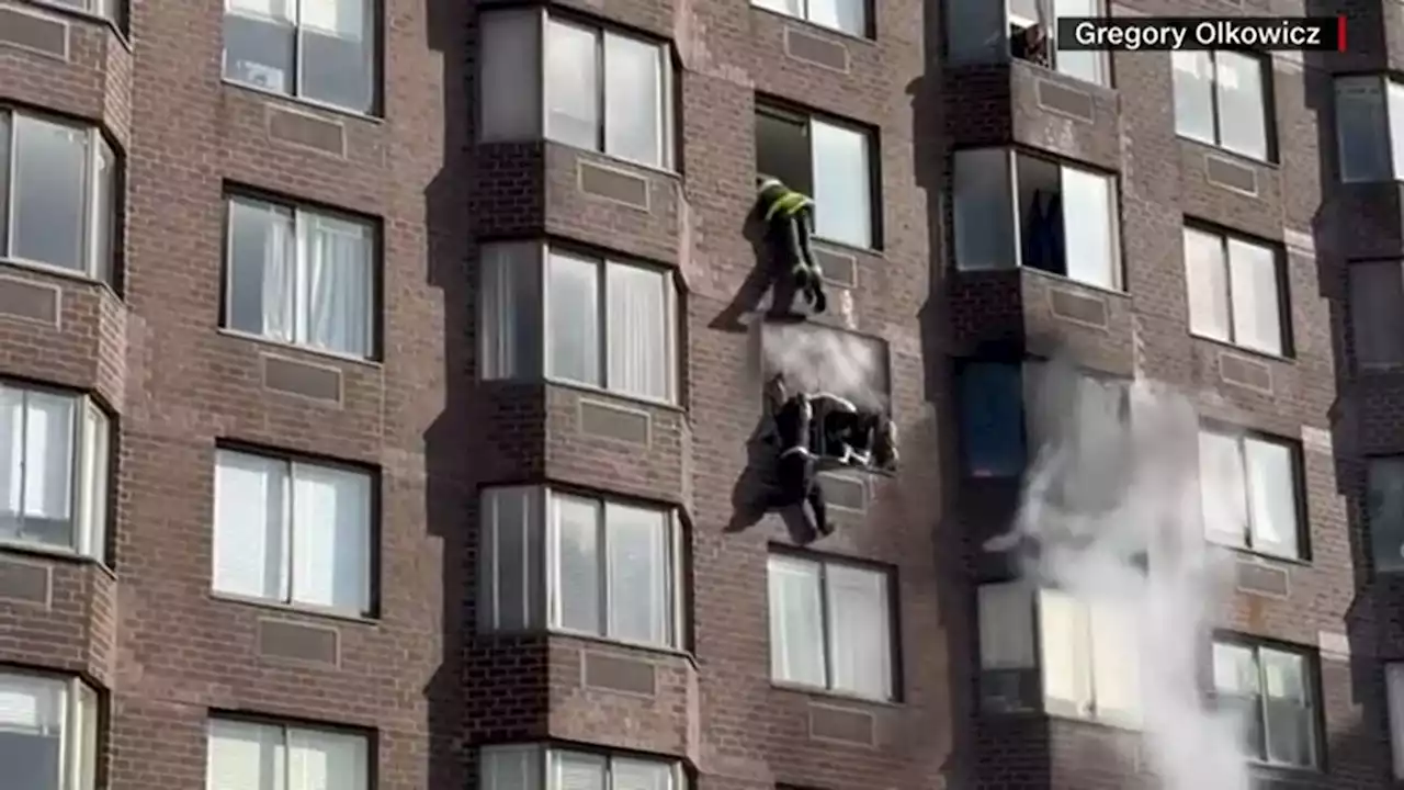 Firefighters rescue woman dangling from 20th-story window