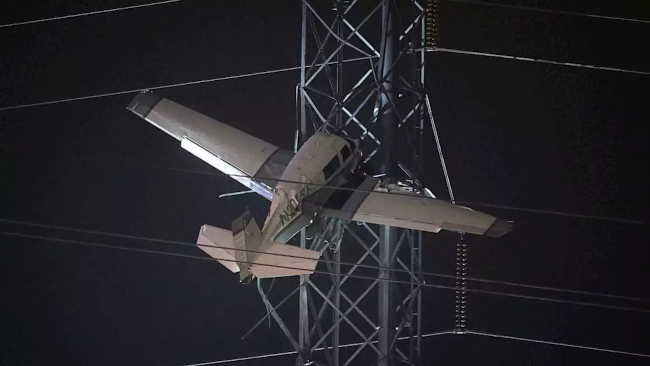 2 trapped in small plane after it strikes high-tension power lines