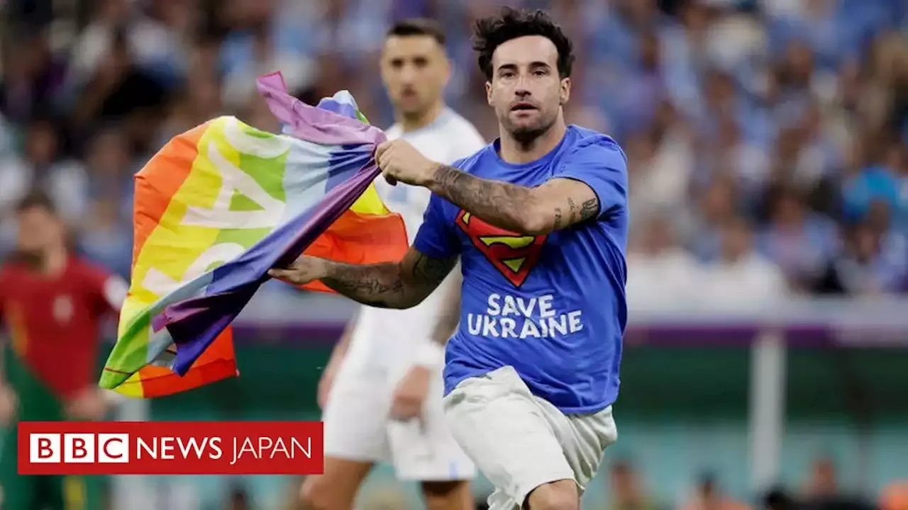 22年サッカーw杯 虹色の旗持つ男性がピッチに乱入 シャツ