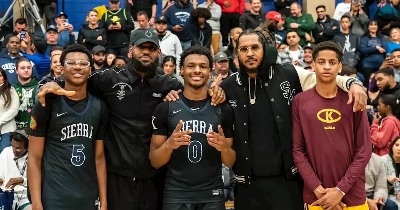 LeBron James and Carmelo Anthony pose with their sons following their high school basketball game