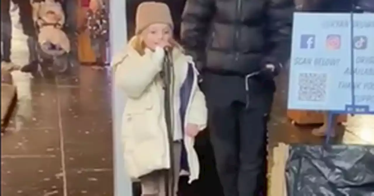 Adorable moment Scots schoolgirl sings to Xmas crowds after getting busker's mic