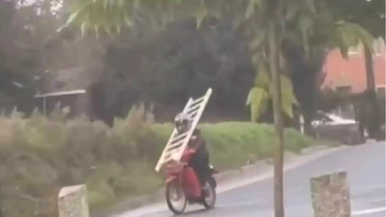 Graban a un motorista circulando con una escalera sujeta al cuello por una carretera de Ordes