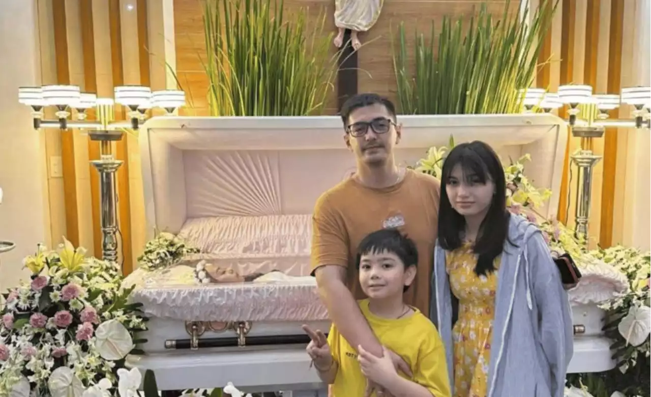 Andrew Schimmer poses near coffin of his wife with kids on Christmas Day