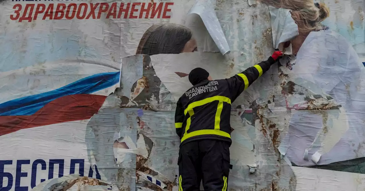 Ukrainians tear down Russian propaganda billboards in Kherson