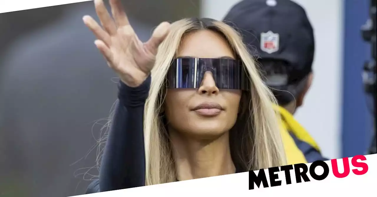 Kim Kardashian looks cool and collected as she throws pass at football game