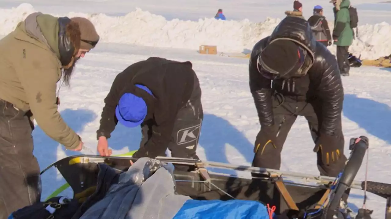 In the heat of competition, Iditarod mushers lend helping hands to one another