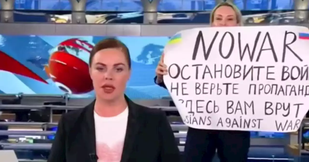 Russian TV employee holds up a sign saying 'No War' during country’s news broadcast