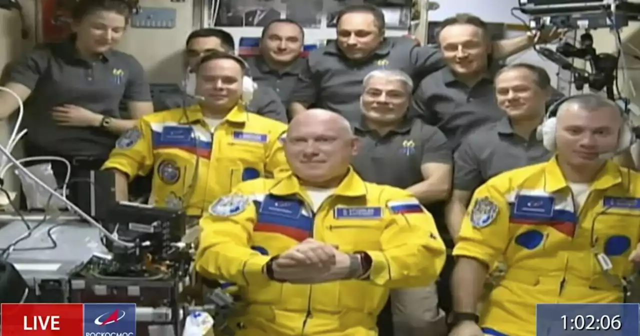 Russian cosmonauts don Ukrainian flag colors as they board space station