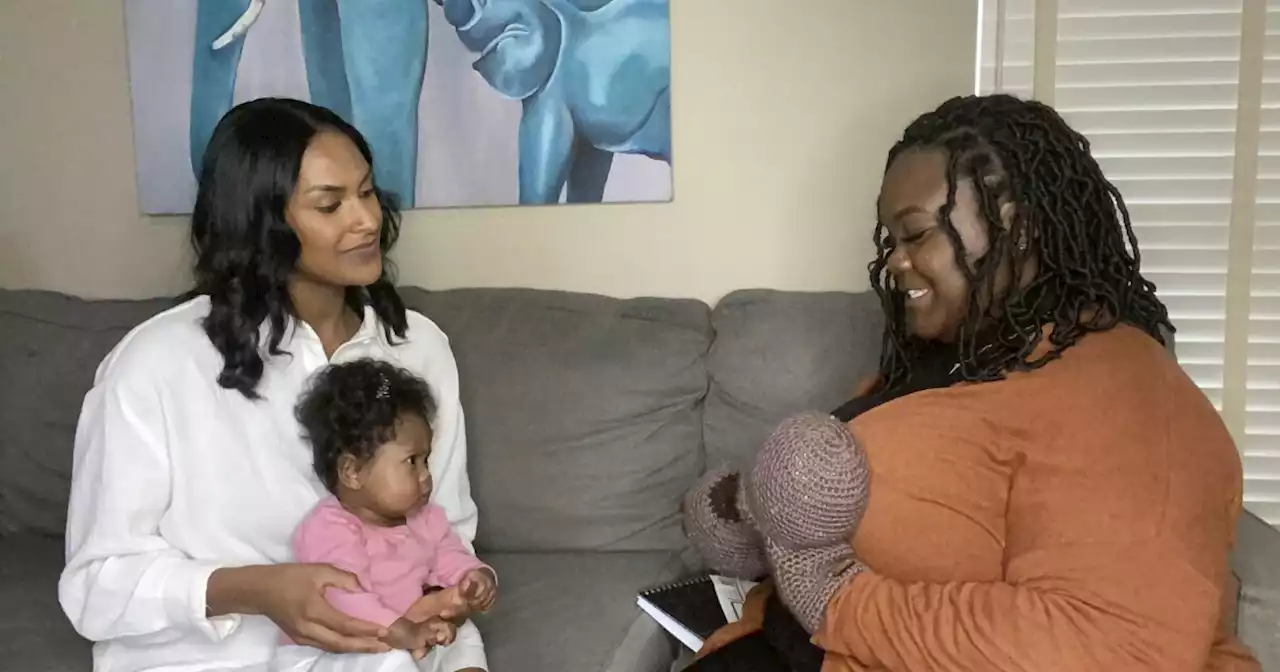 Black lactation consultant guides mothers through breastfeeding