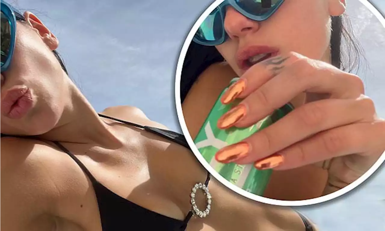 Dua Lipa displays her taut midriff in black bejewelled bikini