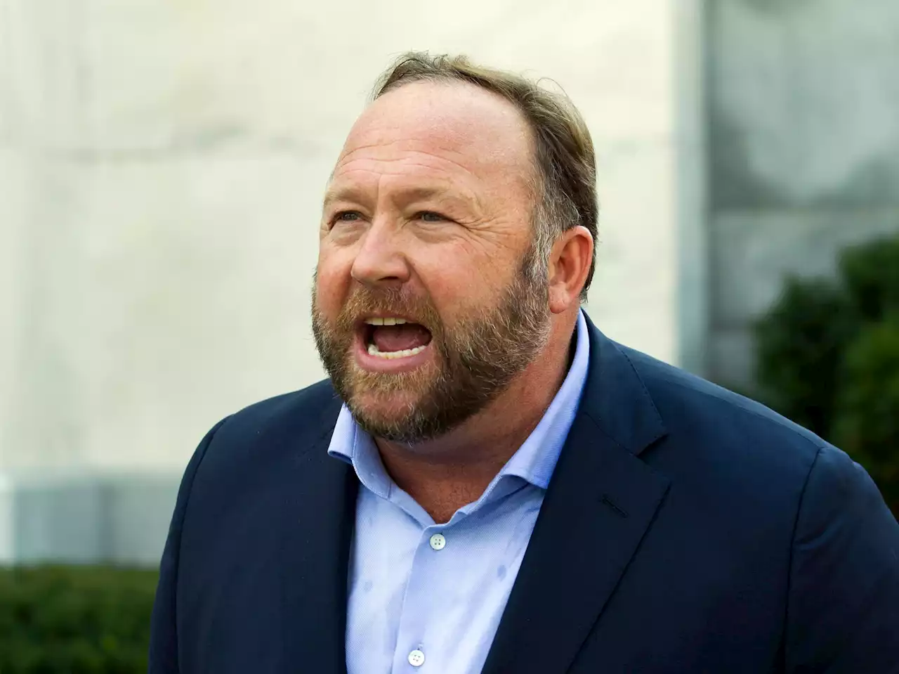 Why is Alex Jones being sued by families of children killed in Sandy Hook massacre?