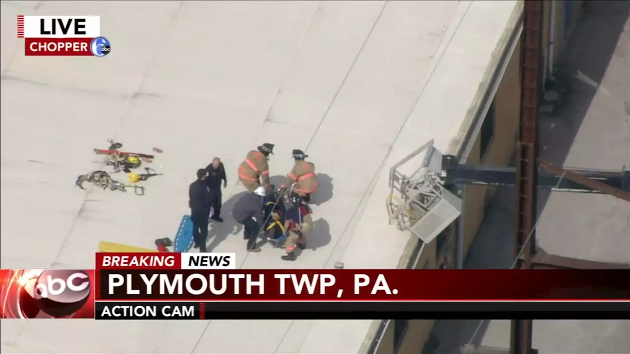 2 workers jump onto building's roof when boom truck tips over in Plymouth Twp.