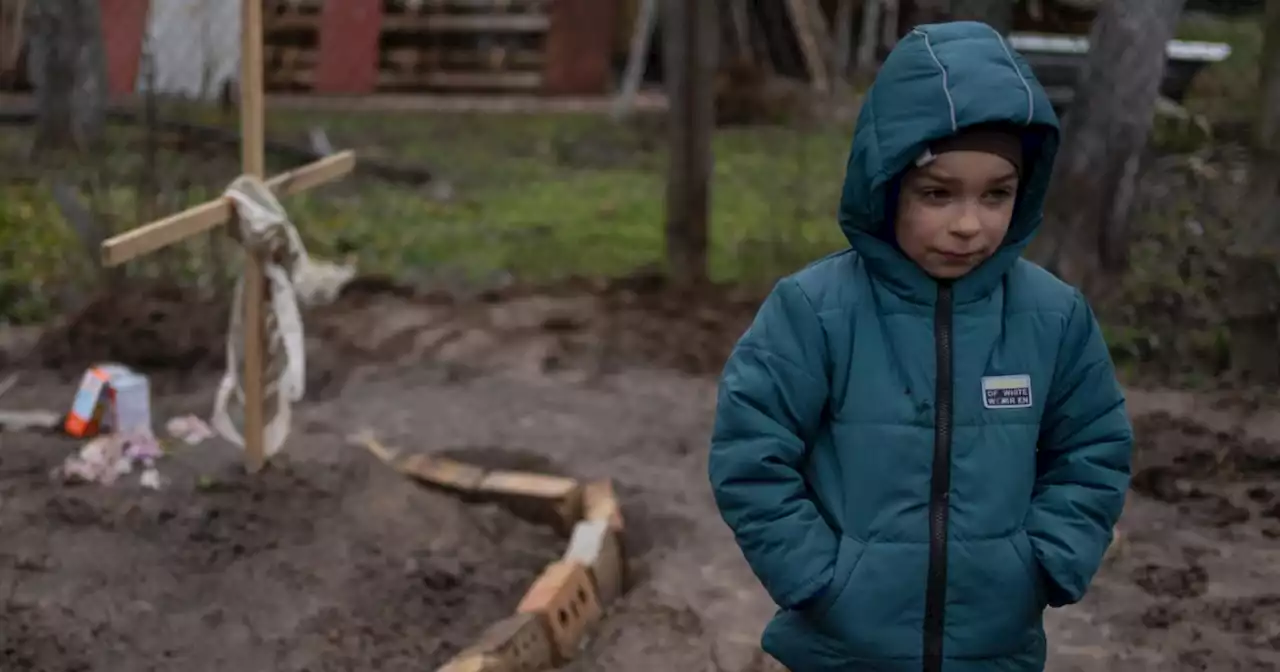 Haunting photo shows Ukrainian child standing watch over mom's grave