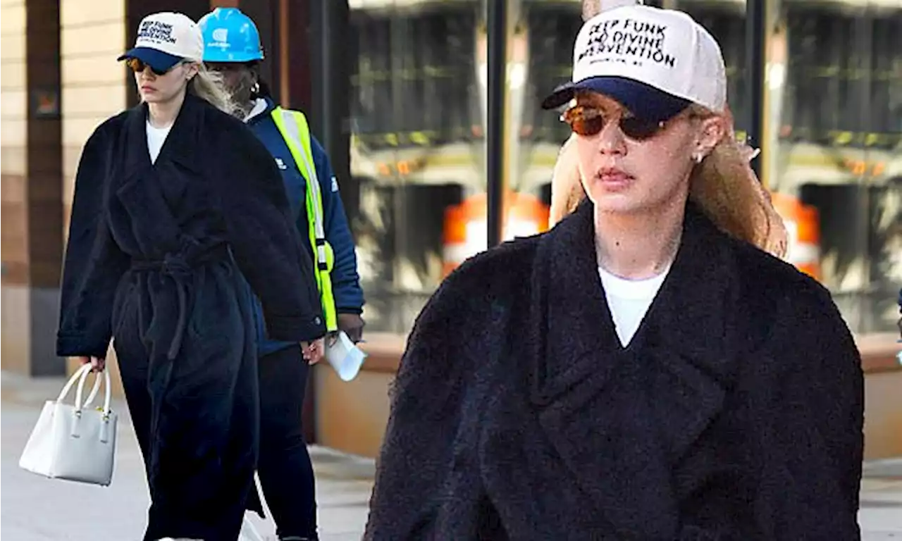 Gigi Hadid bundles up in black terry cloth robe and sweats in New York