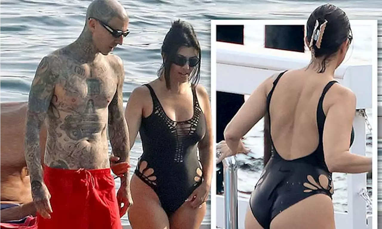 Kourtney Kardashian is seen in a black cut-out swimsuit