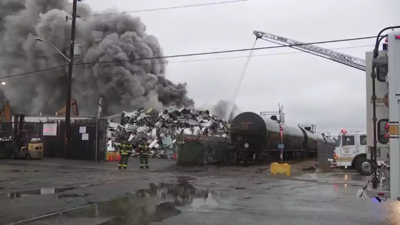 Trash fire billows smoke over I-70, closes Holly Street