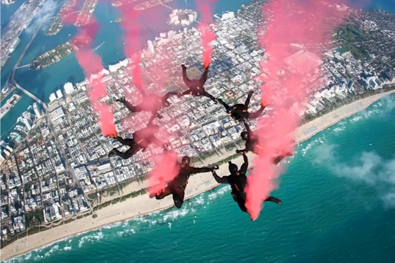 U.S. Army Parachute Team lights the sky red during aerial show in Miami Beach