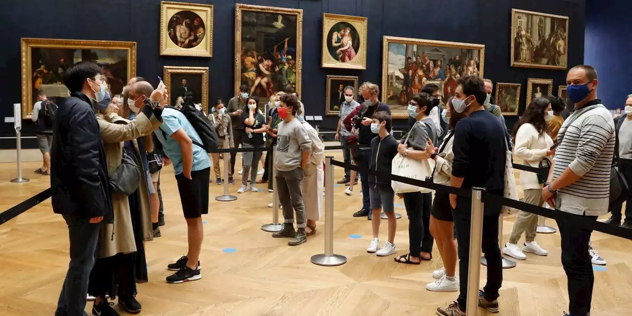 Man in wig throws cake at glass protecting Mona Lisa