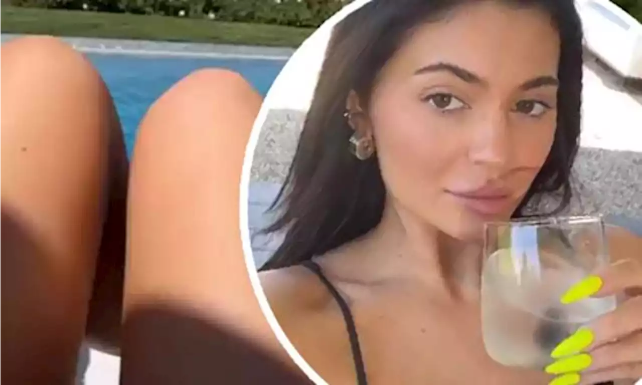 Kylie Jenner sips on a drink while lounging by the pool