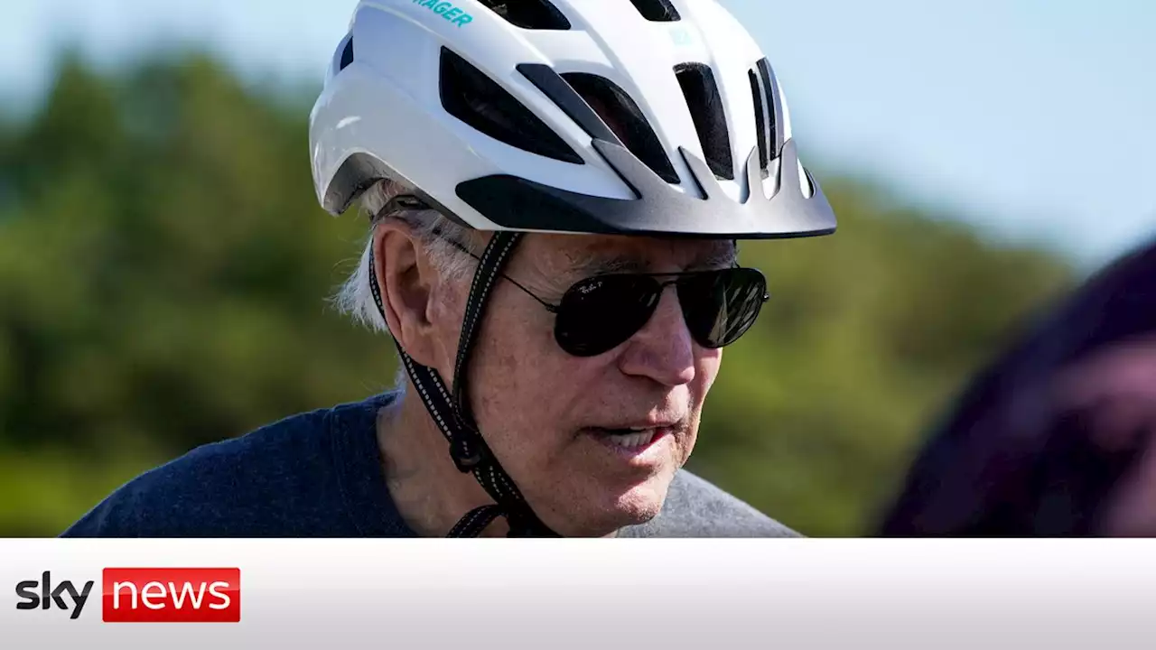 Joe Biden falls while getting off his bike after getting his 'foot caught' following beach ride with wife Jill