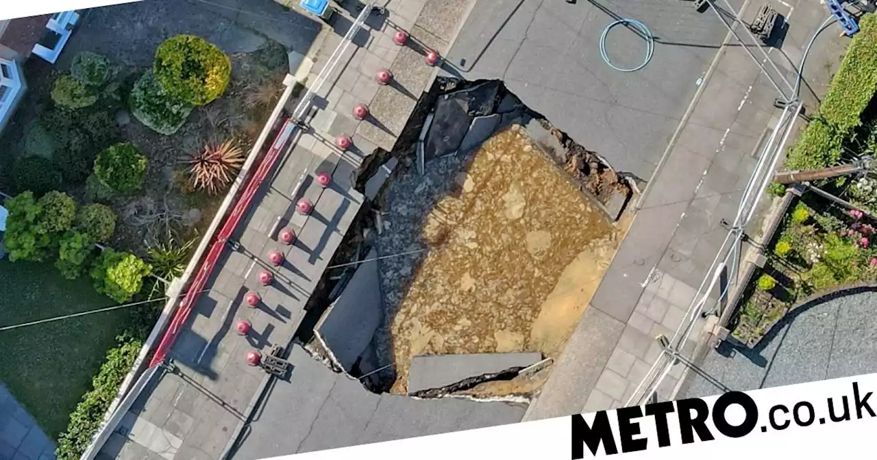 Huge sinkhole opens up across entire road swallowing motorbike in London