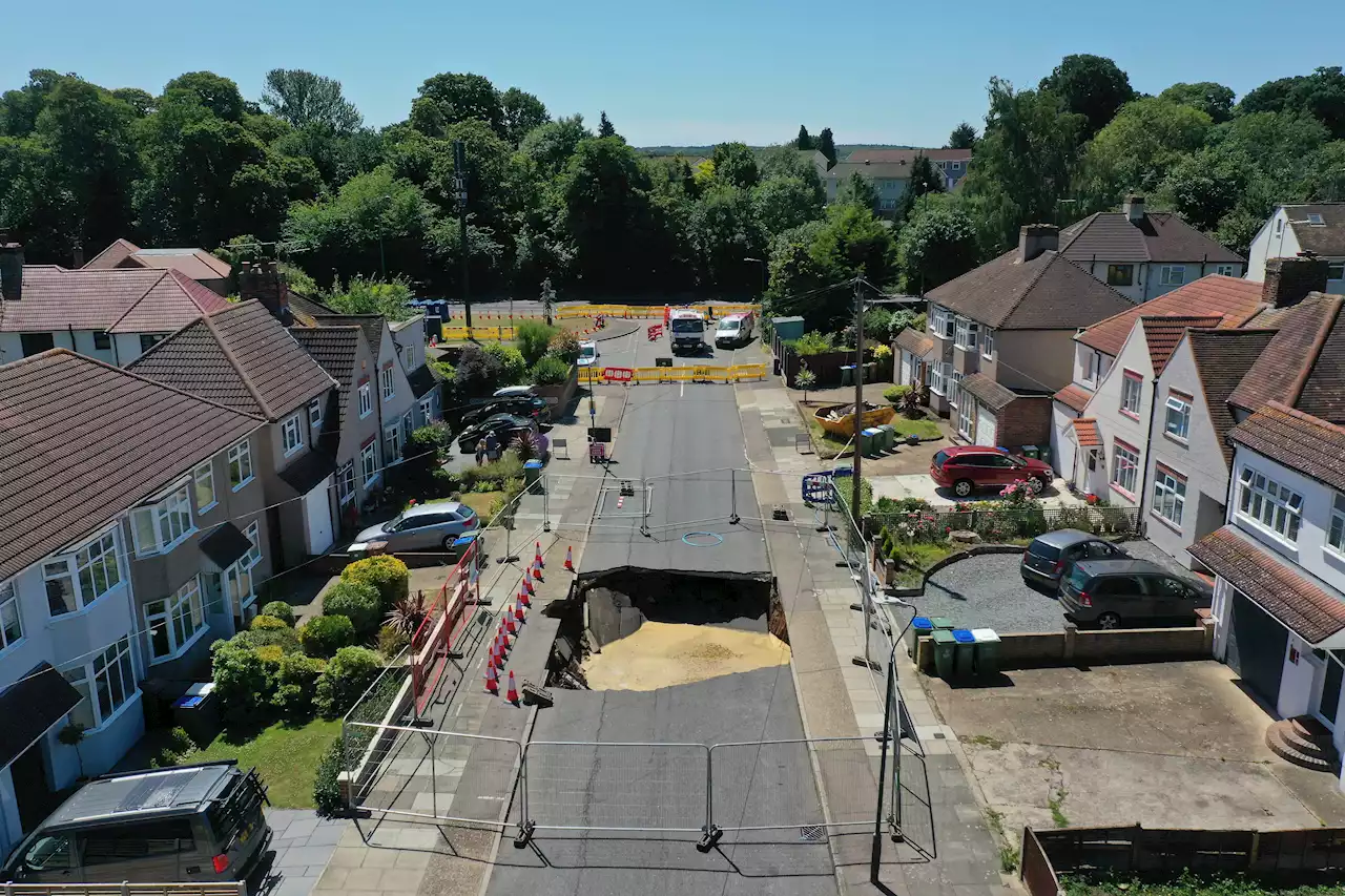 Huge 20ft sinkhole swallows MOTORBIKE after opening on residential street