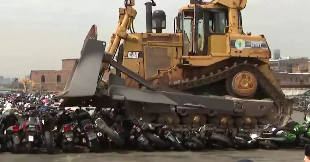 Bulldozer destroys dozens of illegal motorbikes as New York City mayor announces new safety plan