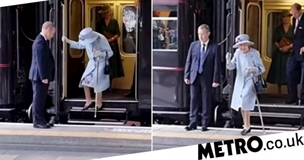 Moment smiling Queen steps off train unaided before waving to onlookers