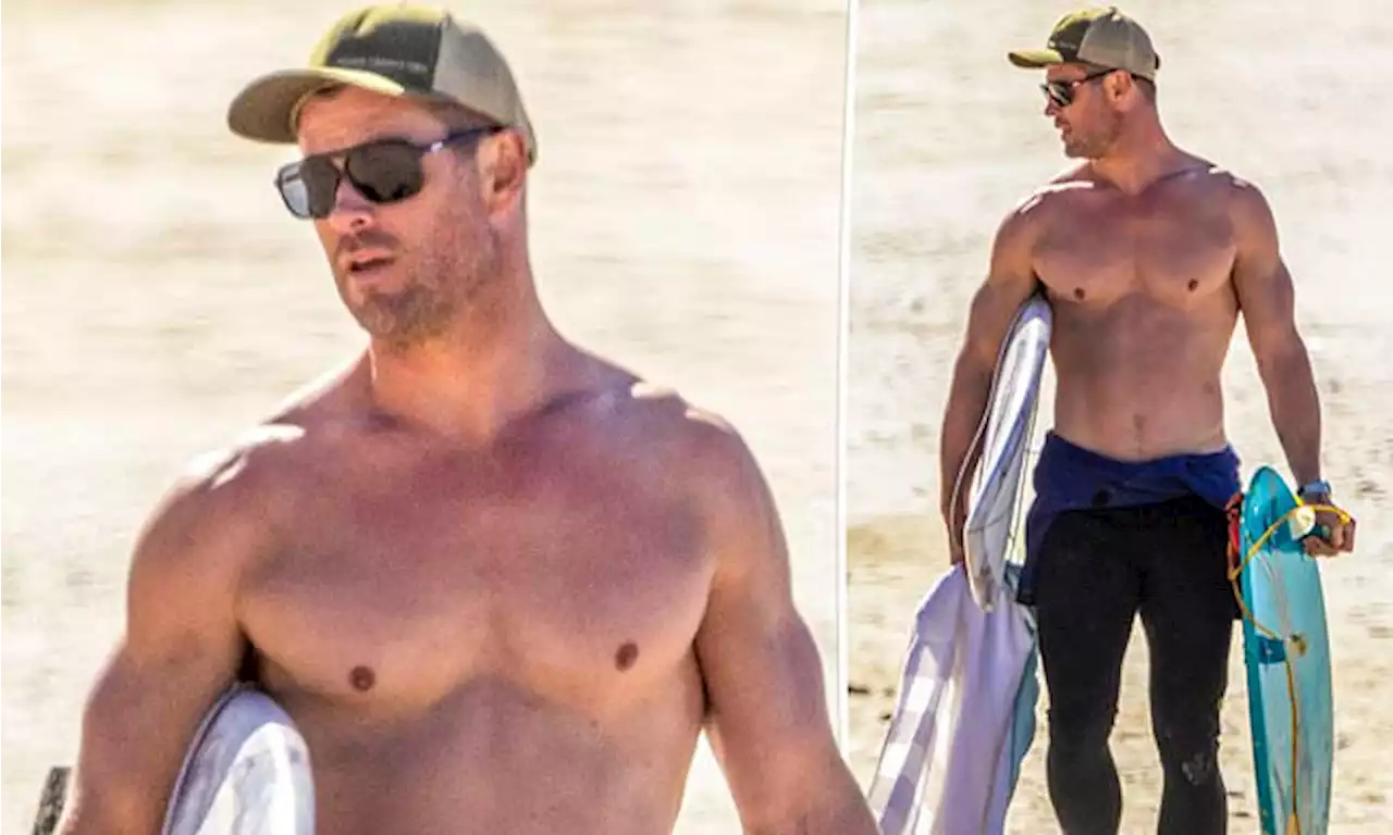 Chris Hemsworth shows off his muscles while surfing in Byron Bay