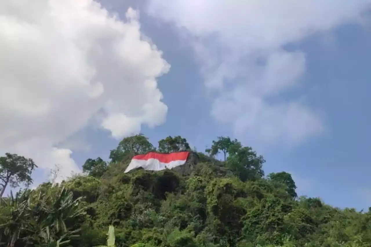 Bendera Berukuran Besar Dikibarkan di Tebing Spagoh Bandar Lampung