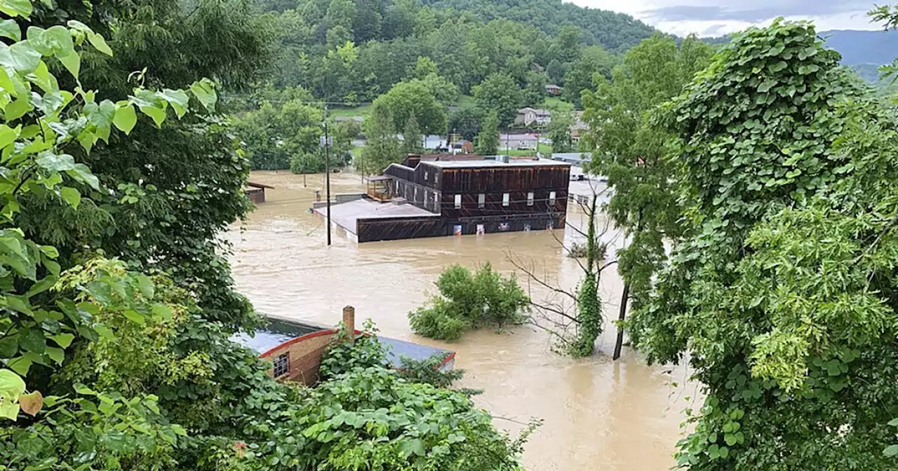 Volunteer firefighters performing rescues as flooding traps residents