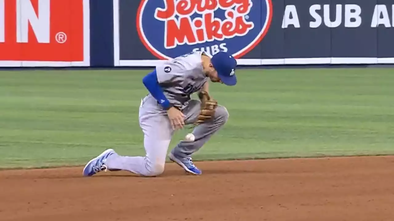 Los Angeles Dodgers' Trea Turner has to field hard ground ball in middle of in-game interview