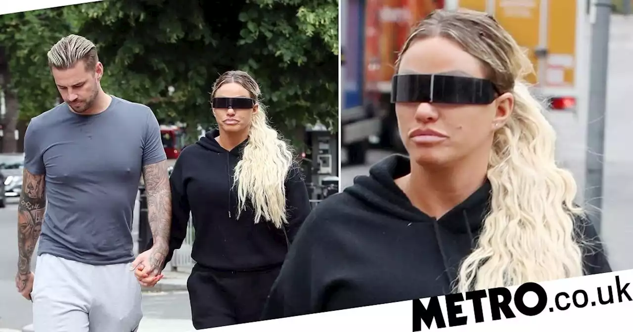 Katie Price holds hands with fiance Carl Woods after he furiously denied split