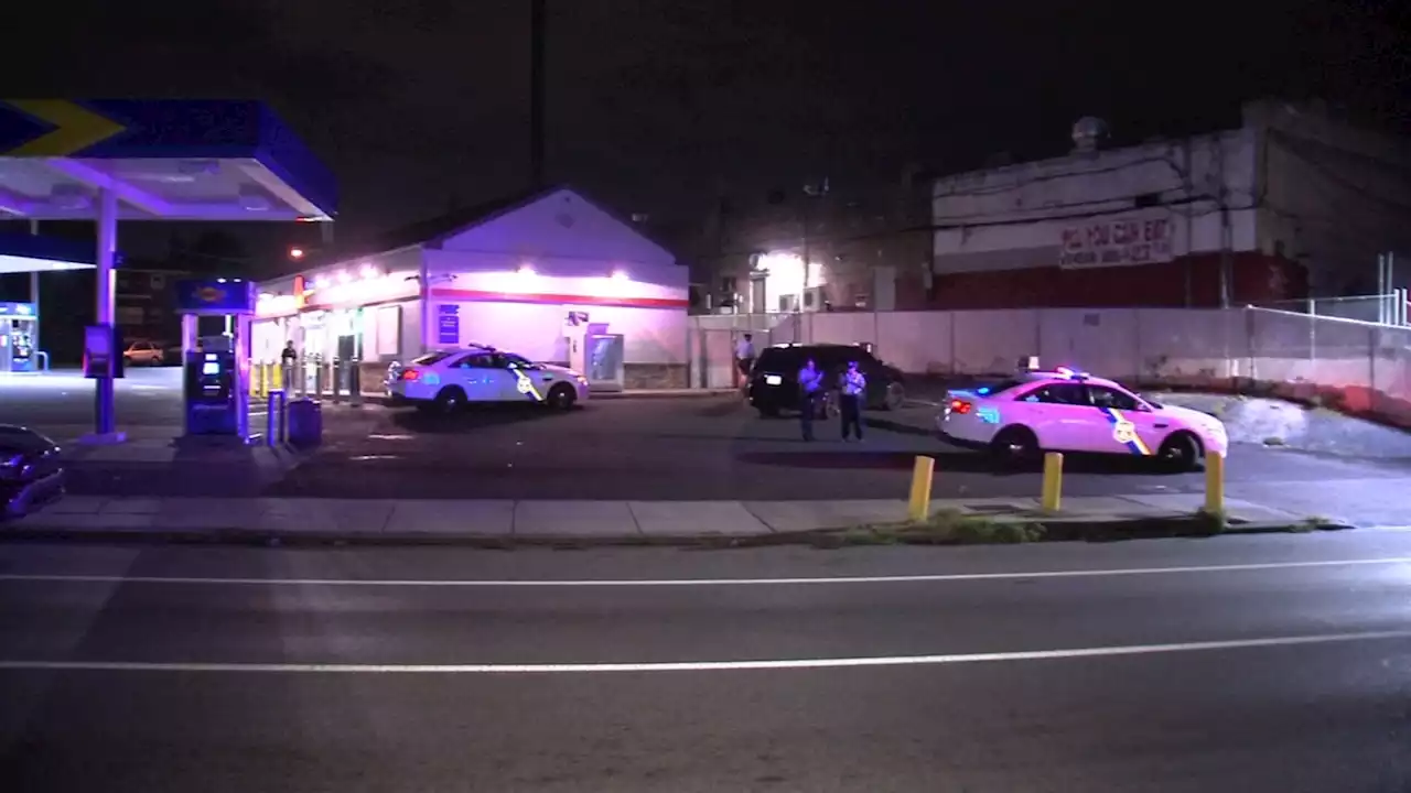 Men pumping air in tire shot at Philadelphia gas station