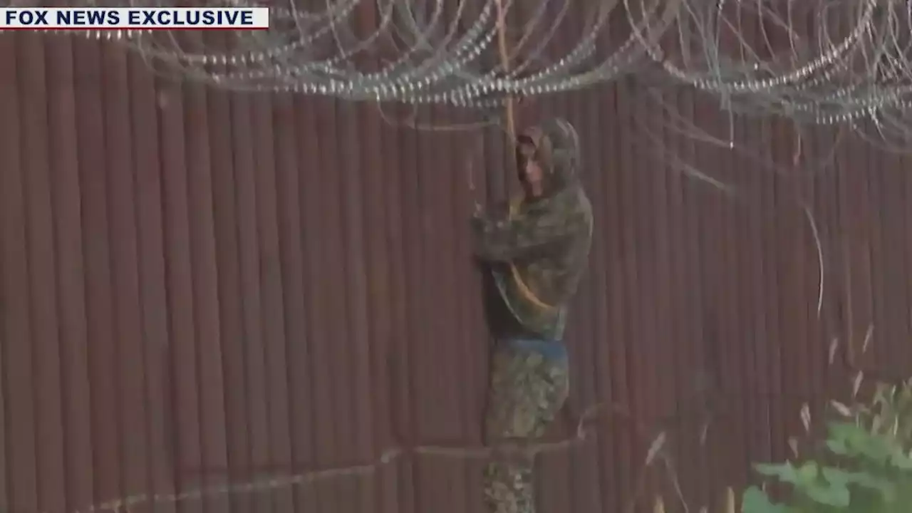 Video captures migrants in camo scaling Arizona wall after Harris says border secure