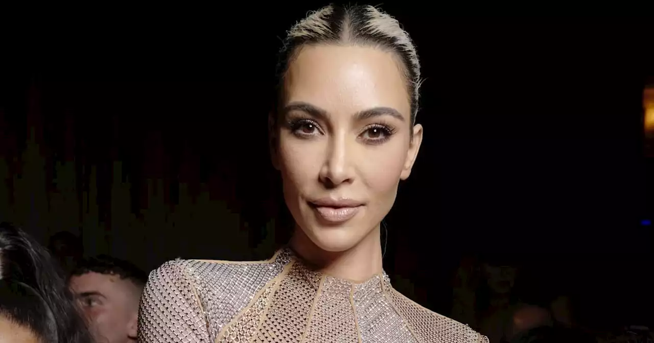 Kim Kardashian Wears a Metallic Swimsuit With Armor-Like Thigh-High Boots