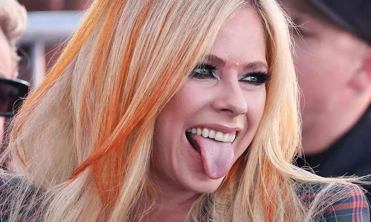 Avril Lavigne looks unreal in fishnets and knee-high boots