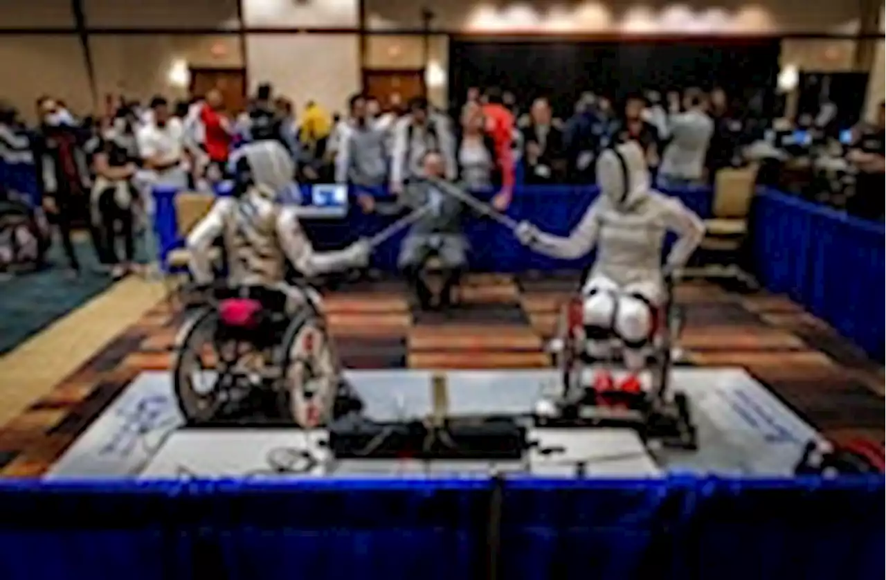 Athletes in wheelchairs parry and lunge in fencing competition in Va.