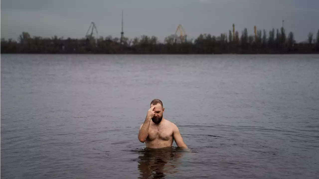 A tradition of plunging in an icy river persists in Ukraine, despite the war