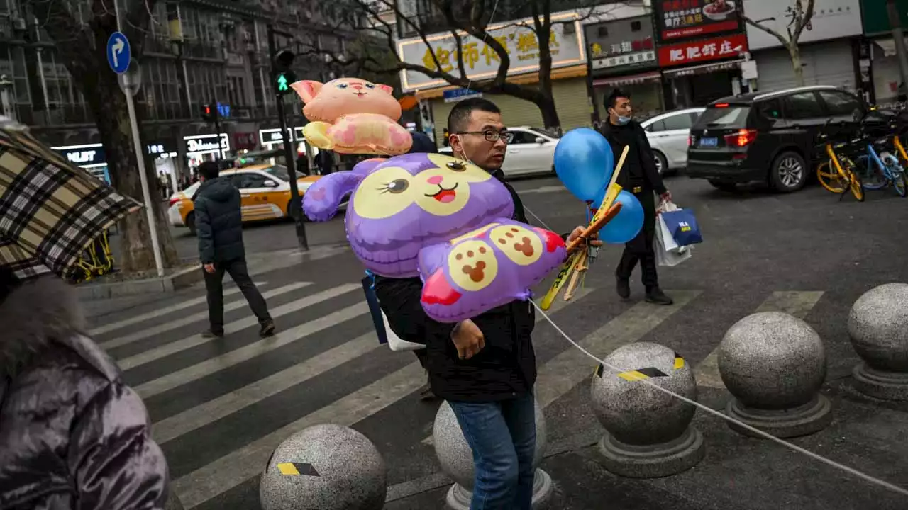 Bustling Wuhan markets celebrate New Year but grief remains