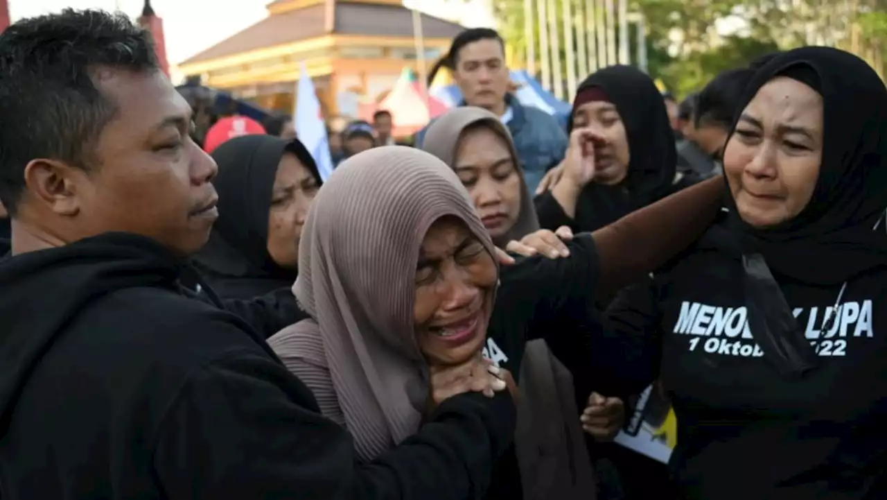 Indonesians pay tribute to victims of stadium crush, fires set on pitch