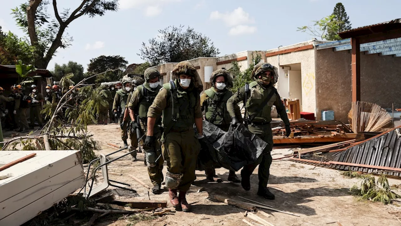 Israeli soldiers collect the bodies of massacred civilians as fighting continues in Gaza and Israel