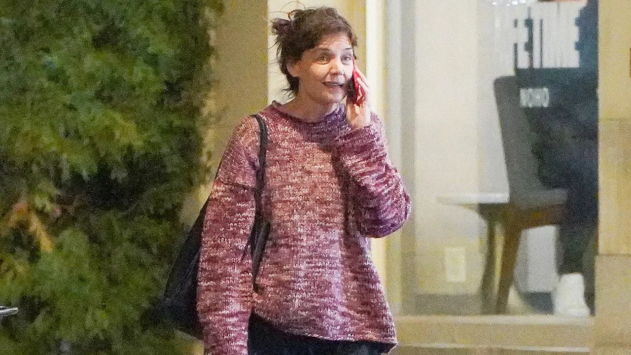 Katie Holmes enjoys a makeup-free evening with her hair in an unfussy bun as she models a bulky...