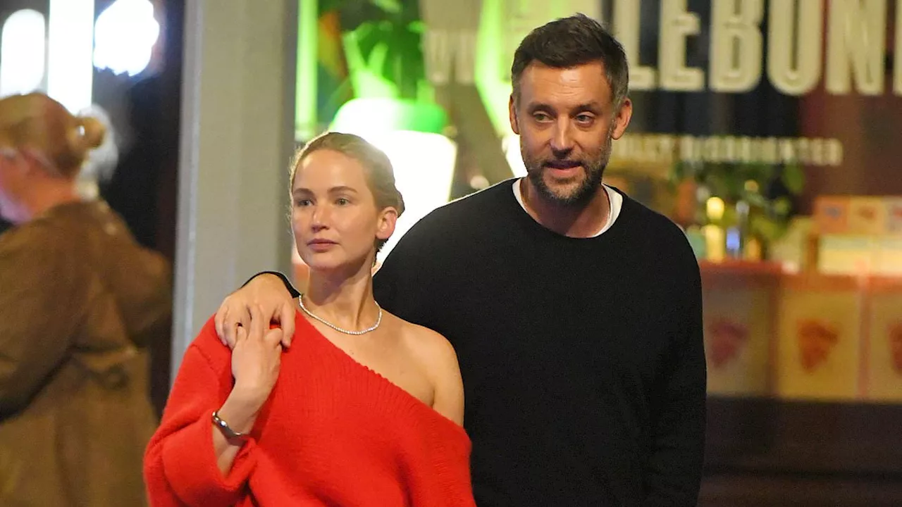 Jennifer Lawrence wears shoulder-baring sweater and holds hands with husband Cooke Maroney during...