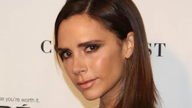 Victoria Beckham stuns in slinky satin dress and fishnet tights